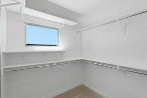 Spacious closet featuring light colored carpet