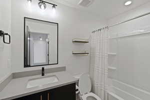 Bathroom featuring vanity and shower / bathtub combination with curtain