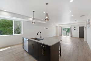 Kitchen with pendant lighting, recessed lighting, an island with sink, light wood-type flooring, and open floor plan