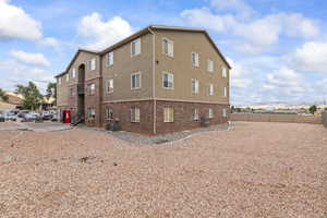 View of side of home featuring brick siding, stucco siding, and a mountain view