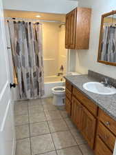 Bathroom featuring shower / tub combo, vanity, and light tile patterned floors