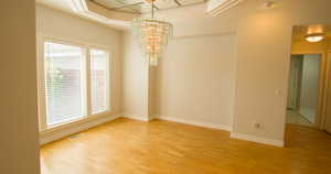 Unfurnished dining area featuring light wood-type flooring and a chandelier