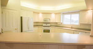 Kitchen with white appliances and white cabinets