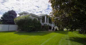 View of property exterior with stairway, a porch, and stucco siding