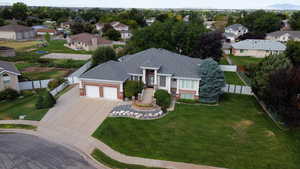 View of front of house with brick, driveway, a shingled roof, and oversized 2 car garage.