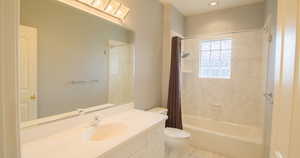 Bathroom with shower / tub combo, vanity, and light tile patterned floors