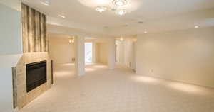 Downstairs living room area with a tiled fireplace, carpet, a ceiling fan, and recessed lighting