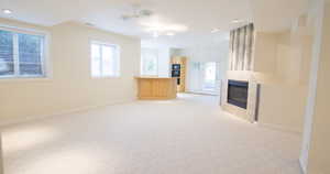 Unfurnished living room with a fireplace and light colored carpet