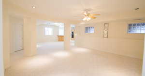 Below grade area with light colored carpet, recessed lighting, and ceiling fan