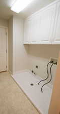 Washroom featuring hookup for a washing machine, cabinet space, gas dryer hookup, and hookup for an electric dryer