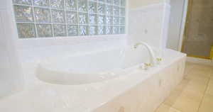 Bathroom with tile patterned flooring, a garden tub, a shower stall, and tile walls