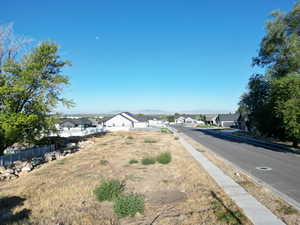 View of asphalt road featuring a residential view, a mountain view, and sidewalks