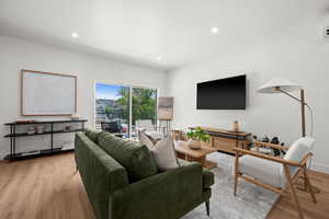 Living room featuring Light Wood-Type Floors and Recessed Lighting with a Sliding Door to a Patio with Views