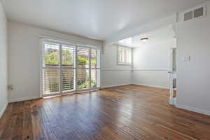 Unfurnished living room with wood finished floors and baseboards
