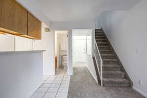 Stairs with tile patterned floors and carpet flooring