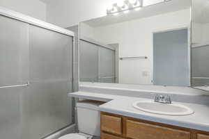Bathroom with shower / bath combination with glass door and vanity