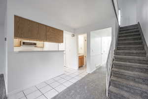Stairs featuring tile patterned floors and carpet flooring