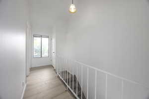 Hallway featuring light wood-style flooring and baseboards