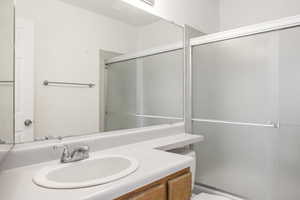 Bathroom featuring vanity and enclosed tub / shower combo