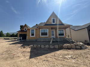 View of front of house featuring covered porch, an attached garage, and brick siding