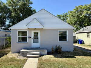 Bungalow-style home with a front lawn and concrete block siding