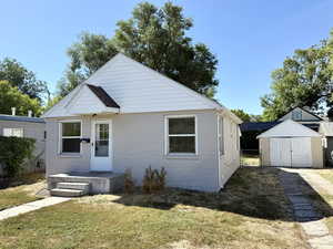 Bungalow-style home featuring a storage shed and a front yard