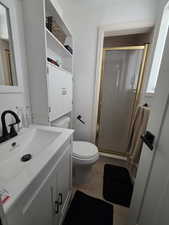 Bathroom featuring a shower stall, vanity, and light wood finished floors