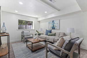 Living area with carpet, recessed lighting, and beam ceiling