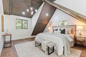 Bedroom with light wood finished floors, vaulted ceiling, wood ceiling, recessed lighting, and a chandelier