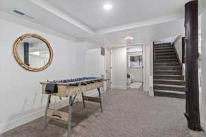 Recreation room featuring light carpet and baseboards