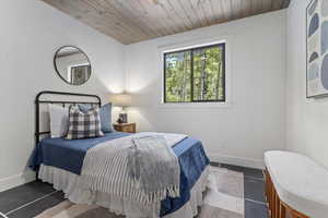 Bedroom featuring baseboards and wood ceiling