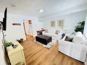 Living room with light wood-style floors and a textured ceiling