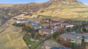 Aerial overview of property's location with nearby suburban area and a mountainous background