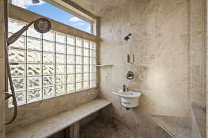Full bath with a tile shower and tile walls
