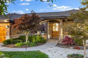 Entrance to property with a shingled roof and a garage