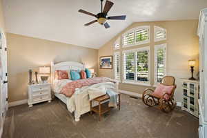 Bedroom with carpet flooring, high vaulted ceiling, and ceiling fan