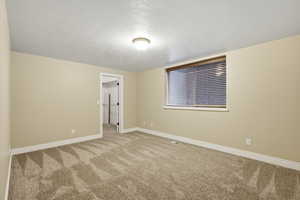 Unfurnished room with a textured ceiling and carpet floors