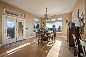 Dining area featuring light wood-style flooring, healthy amount of natural light, and a chandelier