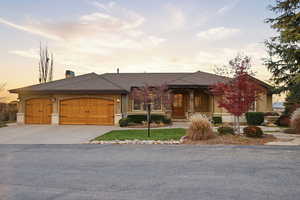 View of front of house featuring a garage, concrete driveway, a chimney, and stucco siding