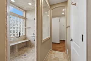 Full bathroom featuring a stall shower, recessed lighting, and stone tile flooring