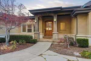 View of exterior entry with a porch and stucco siding