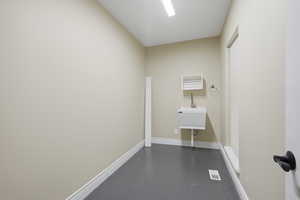 Laundry room featuring concrete flooring and baseboards