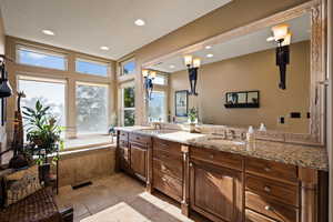 Full bathroom with double vanity, a bath, and recessed lighting