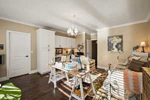 Bedroom with ornamental molding, a desk, multiple windows, wood finished floors, and a chandelier