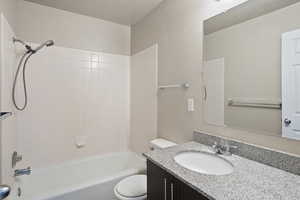 Full bathroom featuring washtub / shower combination, toilet, and granite vanity,