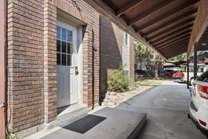 View of exterior entry featuring brick siding
