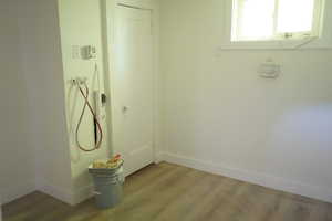 Laundry room with wood finished floors and baseboards