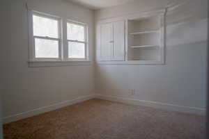 Empty room featuring carpet and baseboards