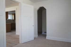 Empty room with arched walkways and baseboards