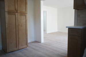 Hallway featuring light wood-style flooring and baseboards